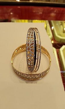 A pair of two-tone gold bangles with fine diamond-cut detailing