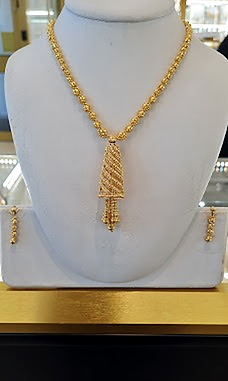 Gold beaded chain necklace with a tapered drop pendant and matching earrings