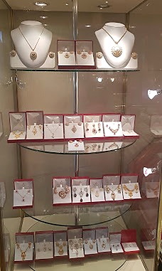 Pendant and earring sets arranged on glass shelves inside Ramzan Jewellers